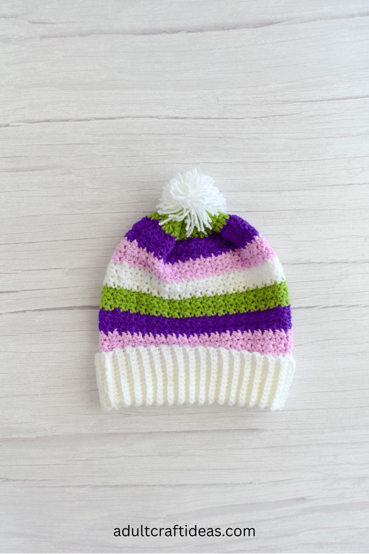 A crochet beanie laid flat on a table.